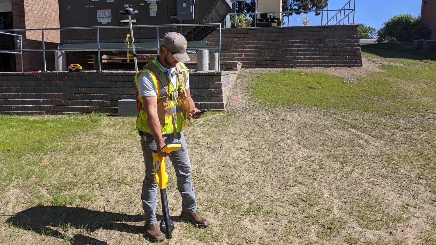 Technician using a utility locator paired with Arrow Gold GNSS to map buried cable