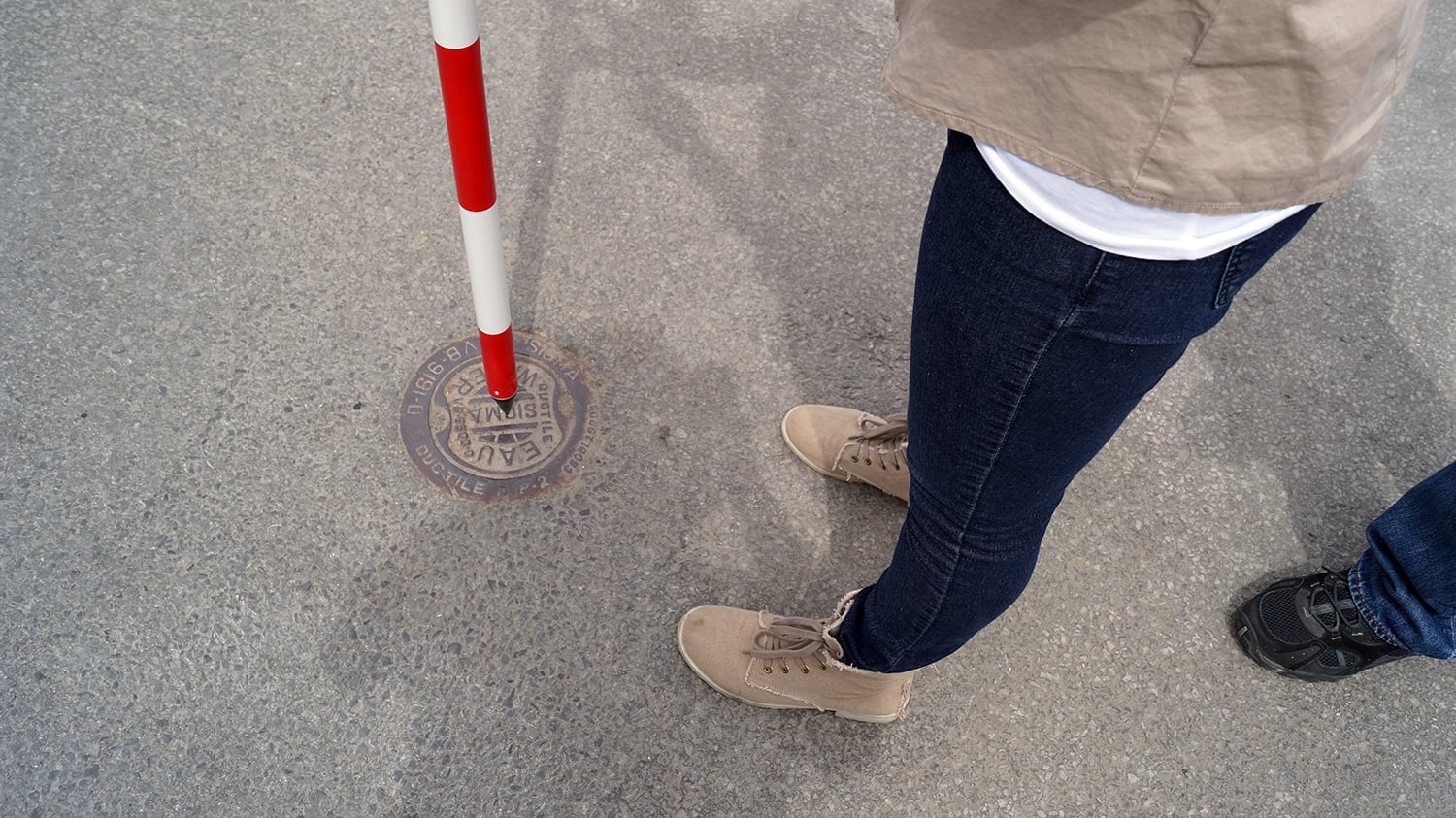 Water utility crew mapping a manhole with an Eos Arrow GNSS receiver on a rangepole
